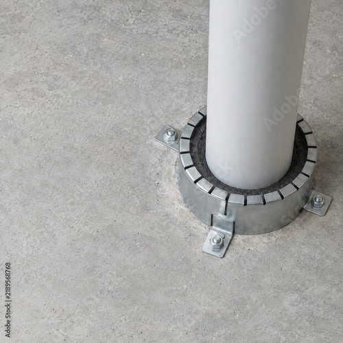 Firestop collar fitted around a pipe through concrete