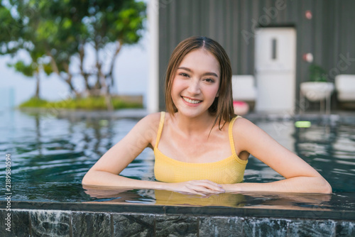 фотографія Radiant young woman relaxing in rooftop infinity pool at twilight, enjoying luxury travel, serene city skyline escape, tranquil wellness, refreshing leisure vacation, and pure blissful hospitality