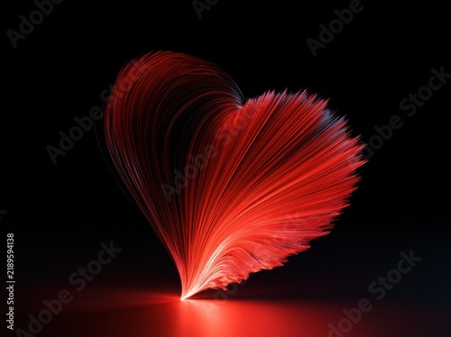 Glowing abstract red heart made of light strands on dark background