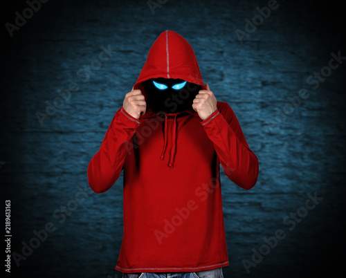 Obraz na płótnie Man in red hoodie with glowing blue eyes.