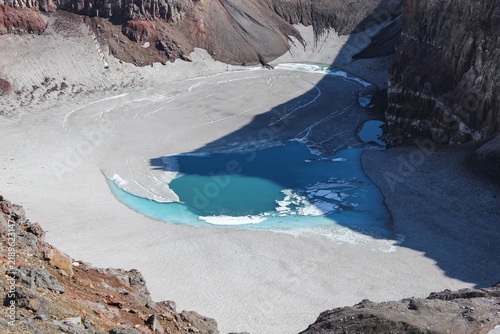 Quadro su tela Acidic turquoise crater lake surrounded by ice inside Gorely volcano caldera, Kamchatka