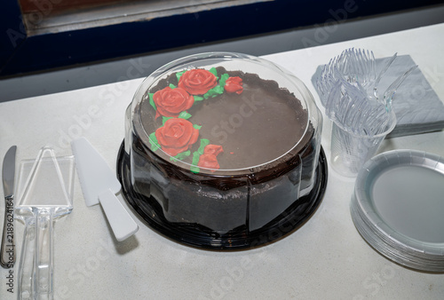 Chocolate cake with red roses and green leaves