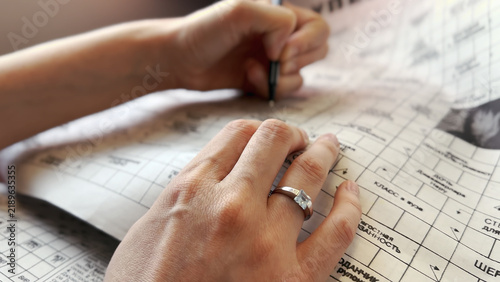 Фотография Female traveler engrossed in crossword puzzles on a train journey
