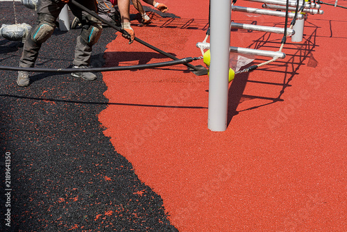 leveling and spreading a new batch of EPDM material using a trowel