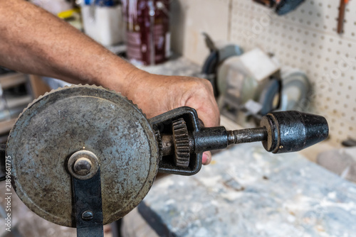 Obraz na płótnie Craftsman using a vintage hand drill in workshop