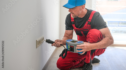 Obraz na plátně A electrician using multifunction tester for revision of electrical circuits