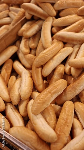 Vertical screen Czech bread rolls displayed in a bakery section with golden baked crust and traditional oval shape showing fresh everyday bread for sale in the food store