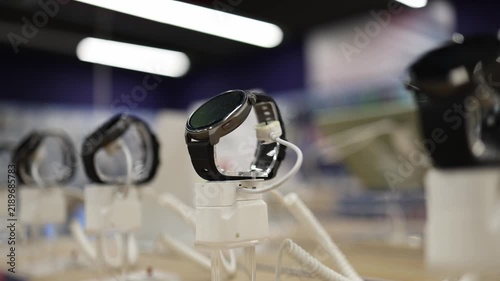 Smartwatches displayed on security stands in electronics store showing wearable technology with touchscreens for customers comparing digital devices before purchase today