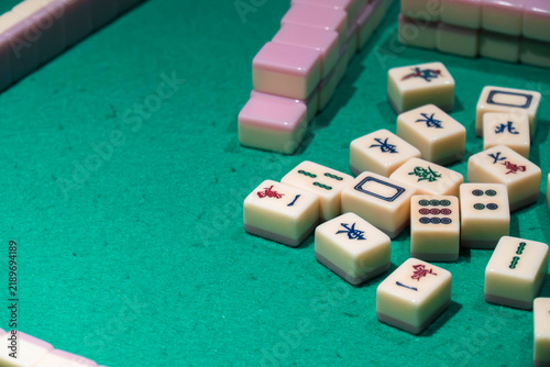 Mahjong Tiles on Green Felt: A close-up shot reveals several mahjong tiles scattered on a green felt surface, hinting at a game in progress.