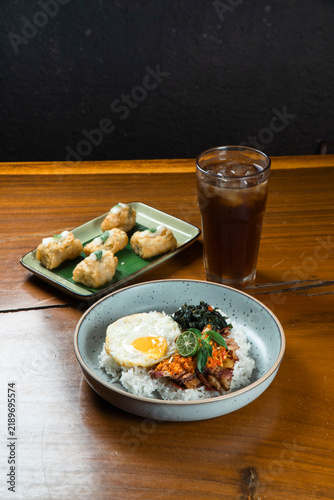 Savory Rice Bowl with Fried Egg and Appetizers: A delicious and satisfying meal featuring a white rice bowl topped with a perfectly fried egg, green vegetables, and savory toppings.
