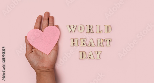 Quadro su tela World Heart Day healthcare awareness concept with open hand holding a pink heart