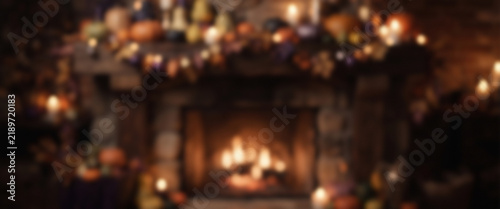 Atmospheric Halloween fireplace scene with softly blurred pumpkins, warm glowing light, autumn decorations, and cinematic bokeh creating a mysterious cozy seasonal background
