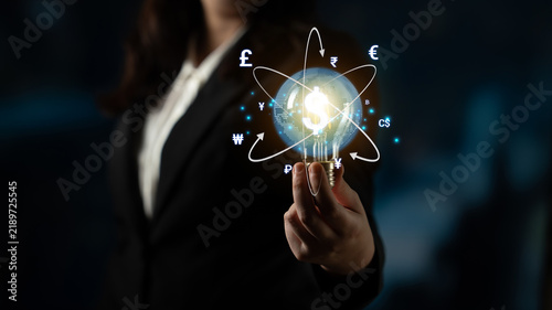 Fotografie Businesswoman Holding a Glowing Globe with Currency Symbols Representing Global Finance and Economic Connectivity