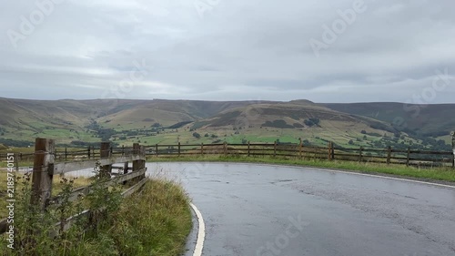 Driving down steep winding road from Mam Tor towards Edale in Peak District, car POV, point of view, driving plate.
