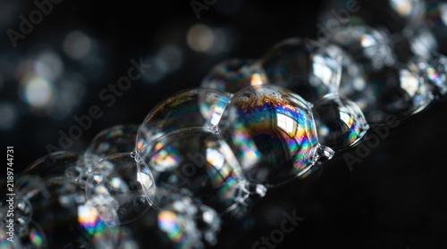 Macro Photography of Transparent Soap Bubbles with Colorful Rainbow Reflections on Black Background