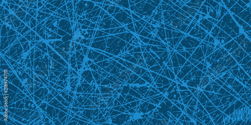 Close up view of the scratched ice surface of a hockey rink showing deep grooves and white marks on the blue painted background after a game