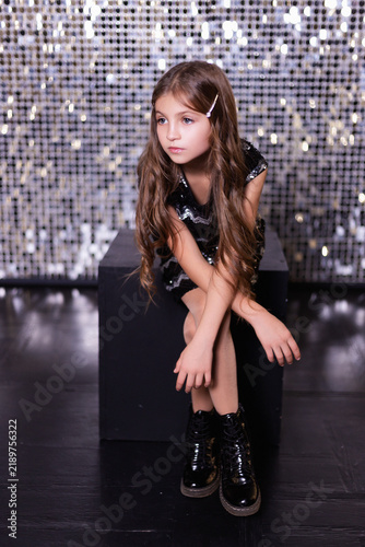 Girl in Sequined Dress Posing on Glitter Background for Holiday Party Concept