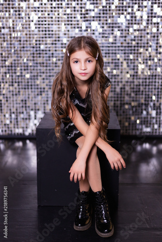 Girl in Sequined Dress Posing on Glitter Background for Holiday Party Concept