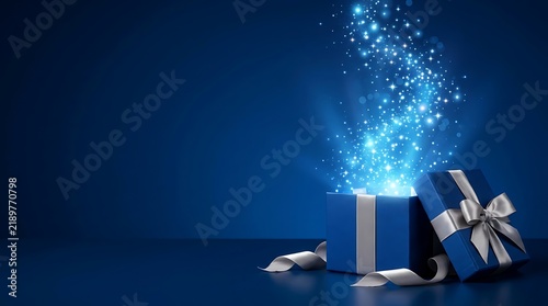 A magical luxury open gift box with glowing blue sparkles and silver ribbon isolated on a dark blue background for festive holiday celebrations