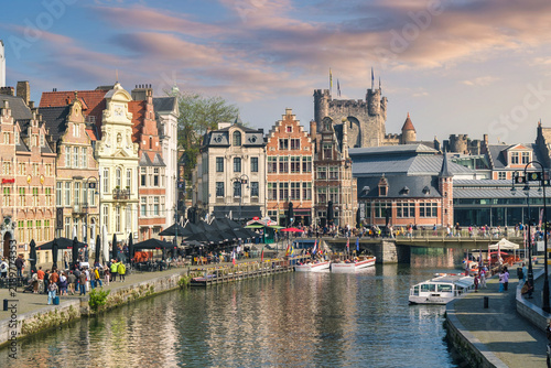 Gravensteen castle skyline over Graslei canal with tour boats and cafe terraces, Ghent