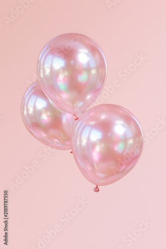 Three pearlescent pink balloons with iridescent reflections floating against a minimal pastel pink background with copy space