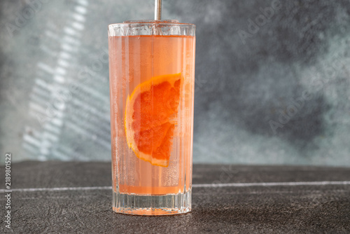 Naklejka Refreshing pink Paloma cocktail with grapefruit ice bubbles and modern metal straw
