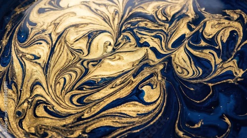 Abstract Macro Mixing of Blue and Gold Liquid Paint