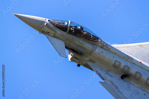 Close up of a fighter jet nose and cockpit against blue sky