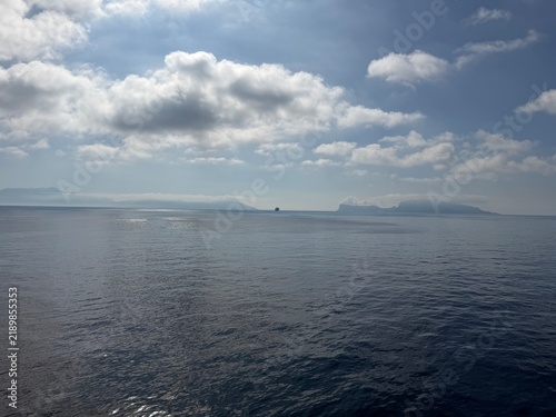 27 April 2026 Italy, Campania, Anacapri, Capri island, Tyrrhenian Sea - large container vessel mist covered Sorrento Peninsula distant view from cruise ship coastline with Marciano and Punta Lagno