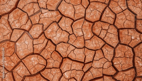 Dry cracked orange desert ground texture showing severe drought and arid soil pattern, natural earth surface background with deep fissures