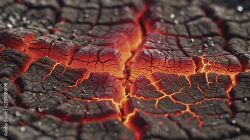 Close up view of burning hot embers glowing intensely inside deep dark cracks across a textured surface