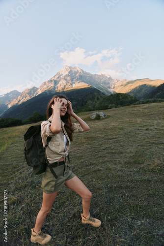 Принти на полотні A woman on a mountain hike with a backpack explores rugged terrain, the distant range behind her, conveying adventure and outdoor lifestyle