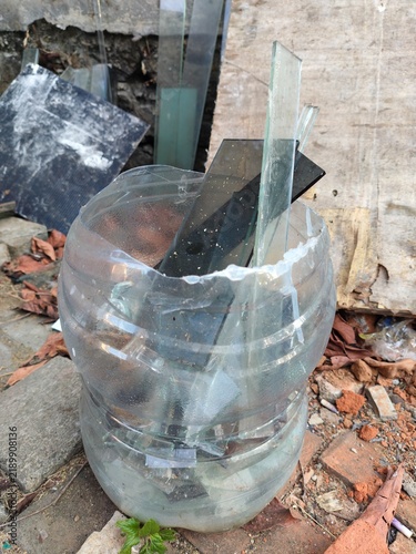 Obraz na płótnie Sharp glass shards safely stored inside a recycled clear plastic bottle