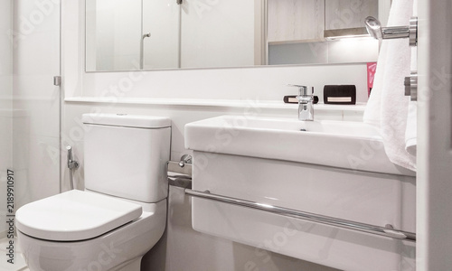 Modern minimalist bathroom interior with white ceramic sink toilet and large mirror featuring clean design for contemporary residential spaces