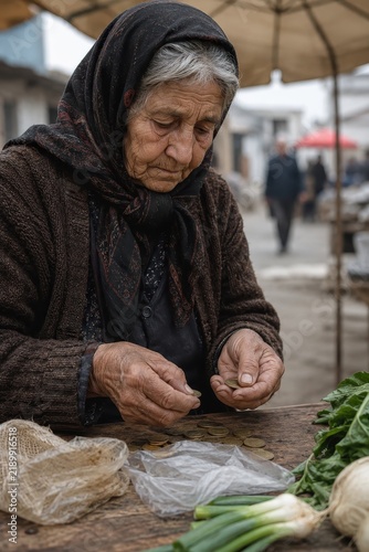 Elderly street vendor counting coins at modest market stall
