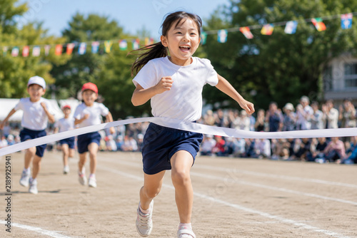 Tapety artystyczne 運動会でゴールテープを切る小学生の女の子