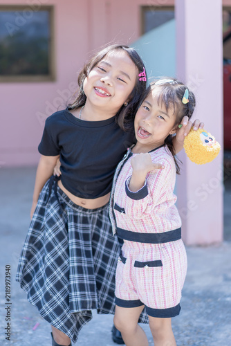 Portrait two cute little girls smiling hugging together outdoor lifestyle youth childhood friends happy joyful cheerful kids playful fun innocent expressions adorable sisters bonding moments