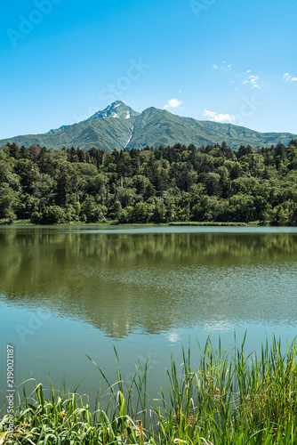 Mount Rishiri and primeval forest reflected on the calm waters of Himenuma Pond, Rishiri Island