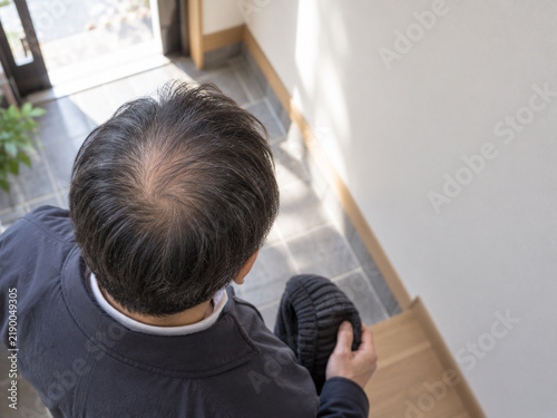 Tapety artystyczne 玄関で帽子を手に持った男性のつむじを上から見た様子