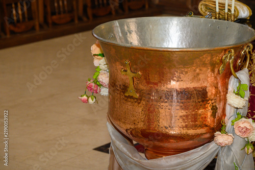 Fotografie Orthodox baptismal font decorated with flowers inside church for christening cer