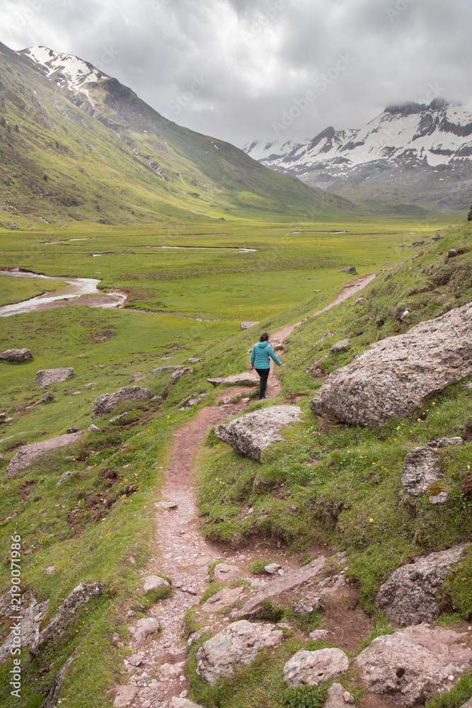 Fototapeta premium Woman hiking mountain trail in pyrenees valley