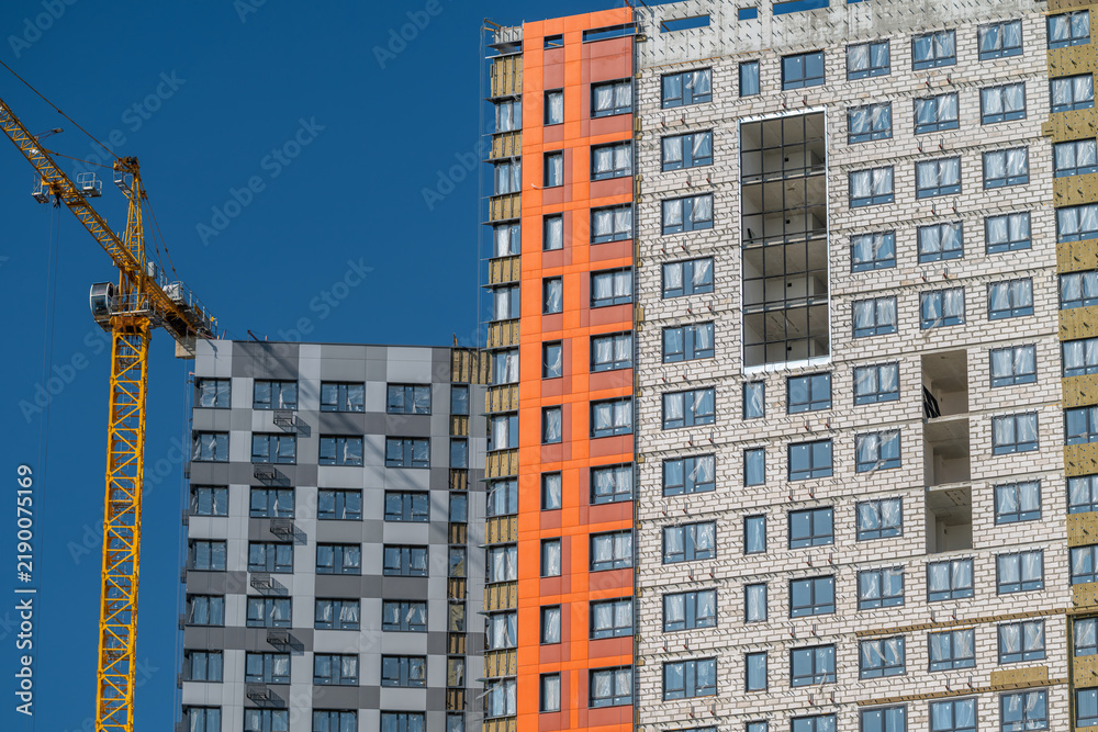Fototapeta premium New apartment complex under construction showcasing modern architecture and vibrant colors in a bustling urban setting