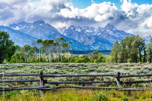 Bild auf Leinwand Mountains with a split-rail fence crossing the sagebrush foreground