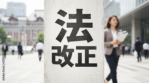 Plakat 「法改正」の文字を強調したオフィス街とビジネスパーソンのイメージ