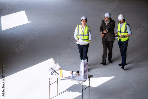 Картината върху платно Senior manager visit walking meeting engineering experts, engineer managers reporting skyscraper construction progress investor site temporary table temporary workspace site