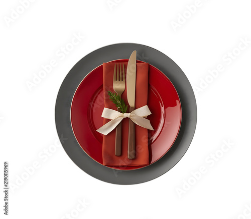 A lonely Christmas plate with some decorations, along with a fork and spoon. Perfect for a New Year holiday backdrop. Aerial view.