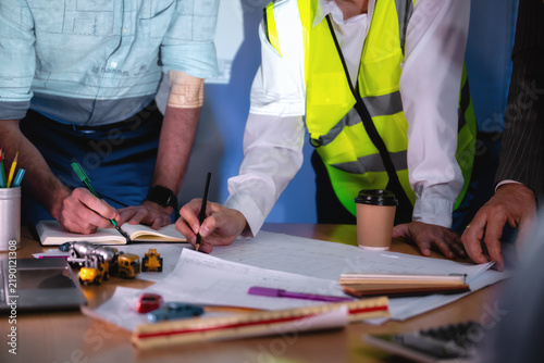 Fotografie Construction management team discussing building layout paper on desk
