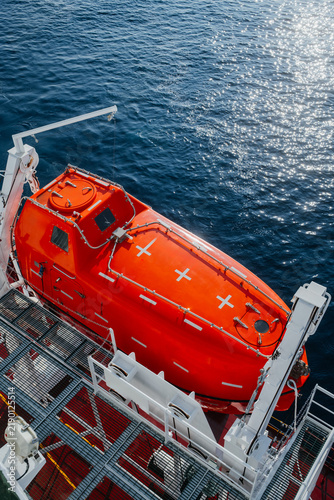 Картината върху платно Orange Lifeboat Secured on Davit Launching System of Commercial Vessel