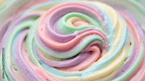 Close up of colorful rainbow pastel buttercream frosting swirl, sweet whipped cream texture background