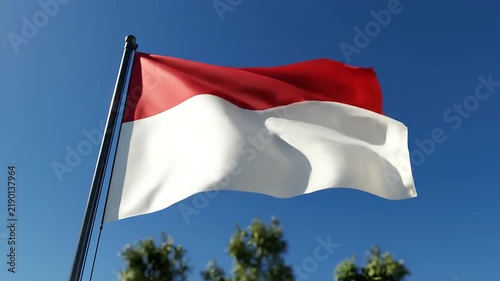 Indonesian national flag waving on a flagpole against a clear blue sky